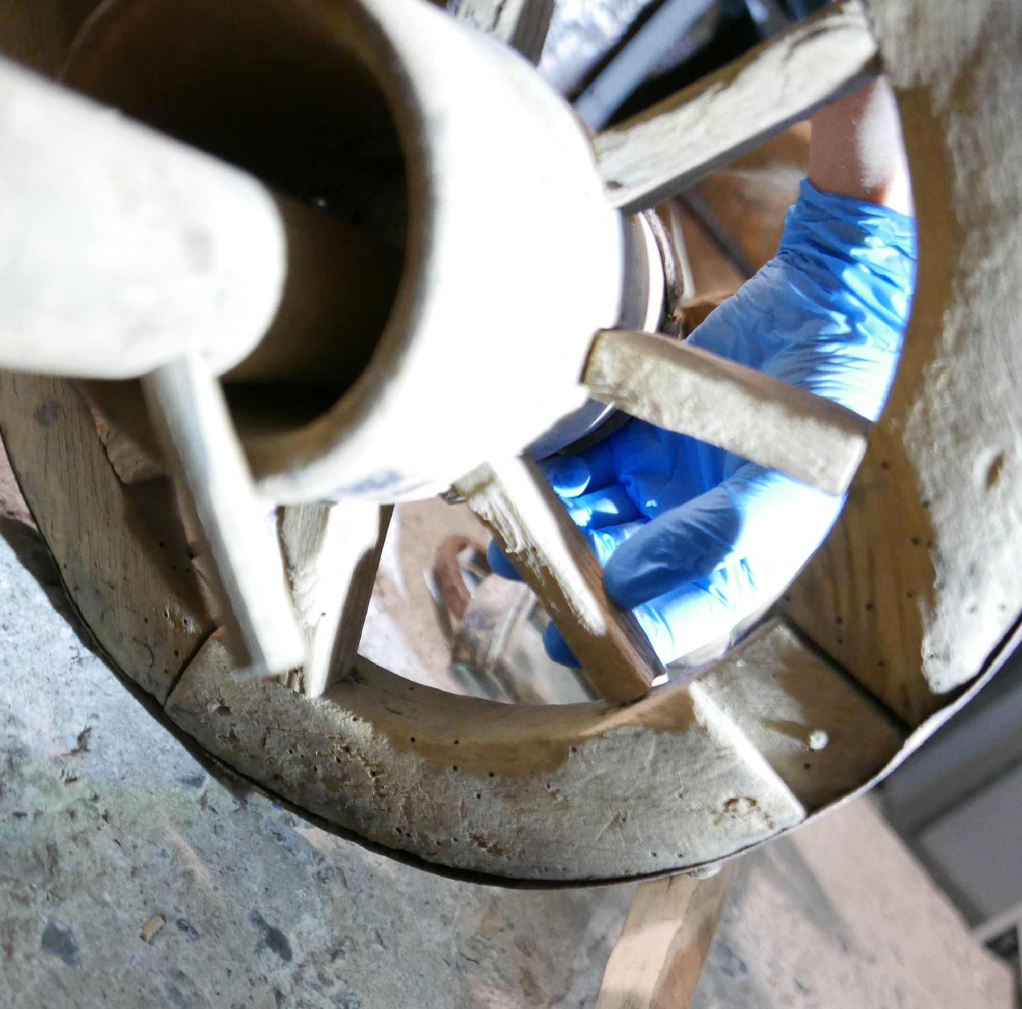 Restauration d’une roue en bois, mains gantées